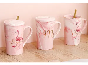 Détail de tasse à café en céramique marbre rose, cuillère dorée élégante et flamant rose.