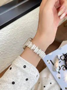 Detailed closeup of the stylish irregular pearl metal watch strap with rhinestones for Apple Watch.