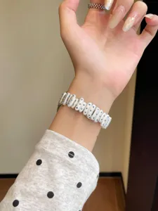 Detail view of white metal watch band with blue rhinestones compatible with Apple watch.