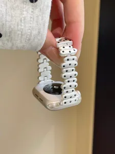 Detailed view of irregular metal watch strap with chic polka dot design for smart devices.