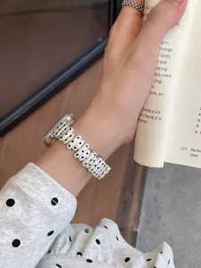 Close-up detail of silver metal polka dot watch strap showing exquisite craftsmanship and texture.