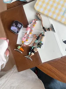 Vue détaillée de bracelets de montre en perles de céramique avec breloques, photo de bureau élégante.