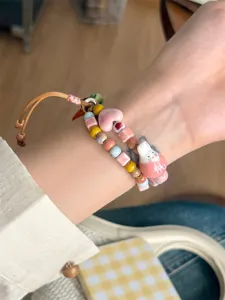 Gros plan détaillé du bracelet de montre tressé en perles de céramique avec un charmant lapin.