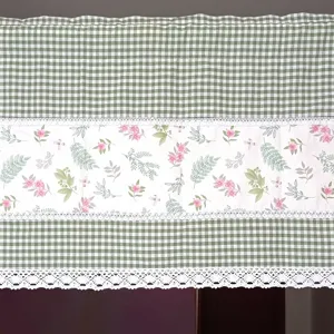 Close-up detail of pastoral style green gingham and floral print curtain with delicate white lace.