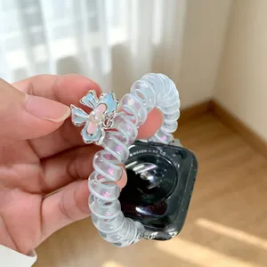 Primo piano dettagliato del cinturino per orologio in fili di telefono scintillante con ciondolo floreale.
