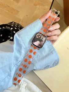 Gros plan sur le bracelet de montre en silicone à pois orange, TPU souple, détail élégant.