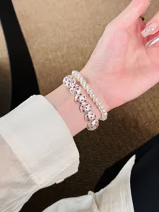 Vue rapprochée montrant le bracelet exquis à double rangée de perles et perles argentées.
