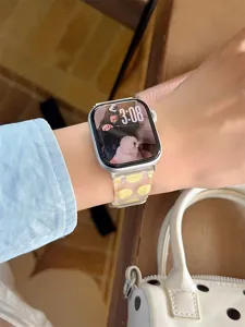 Gros plan de détail du joli bracelet de montre en silicone à pois jaunes au poignet.
