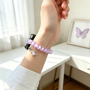 Vue rapprochée du bracelet de montre en fil de téléphone violet avec un joli charm papillon.