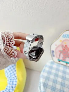 Bracelet de montre en cuir blanc avec decoupes de pattes de chat et boucle deployante.