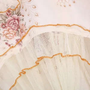 Vista detallada de una elegante cortina de encaje con estampado floral vintage y bordes naranjas.