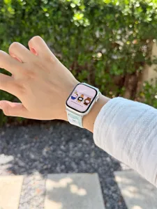 Close-up detail of the cute polka dot silicone watch strap worn on wrist, soft texture.