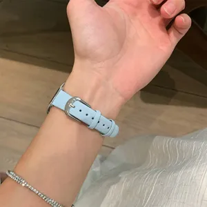 Light blue leather watch strap buckle detail on wrist, soft texture and durable metal clasp.