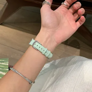 Light green leather watch strap detail view, elegant metal buckle, comfortable daily wear.