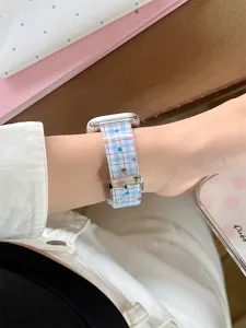 Close-up detail of the colorful dot plaid silicone smartwatch strap worn on wrist.