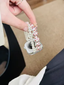 Vue detaillee du bracelet de montre en perles style Chanel avec strass rouges pour Apple Watch.