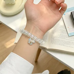 Bracciale a spirale trasparente per telefono con grazioso ciondolo a fiocco blu, elegante.