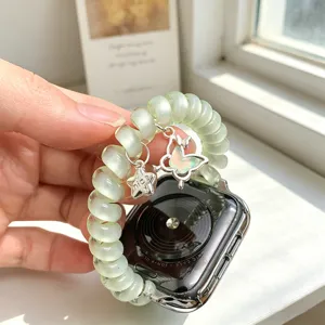 Bracelet Apple Watch fil téléphonique avec charm papillon et étoile, vue de détail.
