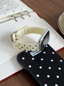 Close-up detail shot of the silicone watch strap with cute black heart pattern on a desk.