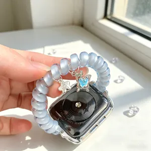 Bracelet de montre spiralé bleu transparent avec pendentif papillon et étoile, détail.