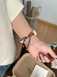 Gros plan sur le bracelet de montre en perles de céramique avec cordon tressé et perles.
