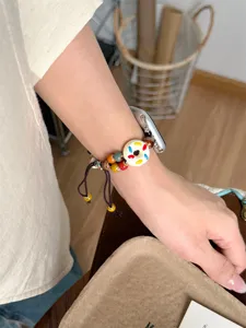 Gros plan détaillé du bracelet de montre tressé en perles de céramique avec texture.