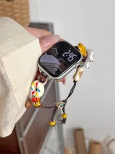 Gros plan détail du bracelet de montre en perles de céramique fait main avec de jolis charms.