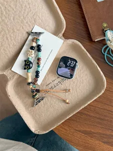 Gros plan détaillé du bracelet de montre en perles de céramique avec chat mignon.