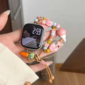 Bracelet de montre en céramique tressée et perles avec breloques carotte et cœur.