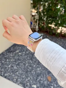 Detailaufnahme eines lichtdurchlaessigen, mattierten Silikonarmbands mit bunten Punkten.
