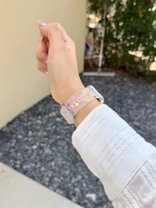 Nahaufnahme des transparenten Silikonarmbands mit bunten Punkten am Handgelenk getragen.