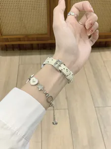 Leather watch strap detail shot with star pattern and cute metal charms for smart watch wrist wear.