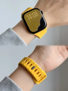Detailweergave van de siliconen band met geel gestructureerd ontwerp en veilige gespsluiting.