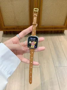 Detail view of brown leather star watch strap for Apple Watch with gold buckle pin.