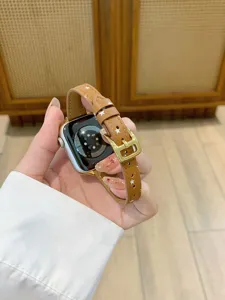 Close-up detail of brown leather watch band with cute white stars and gold metal buckle.