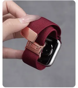Close-up van de wijnrode geweven nylon vervangende horlogeband met metalen magnetische gesp.