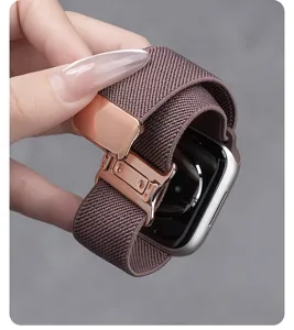 Close-up van het geweven nylon horlogebandje met roségouden magnetische sluiting.