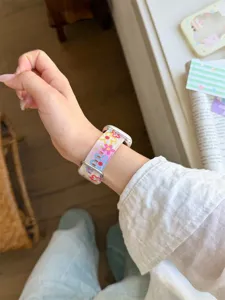 Vista dettagliata del cinturino in silicone con fiori colorati, morbido e confortevole.