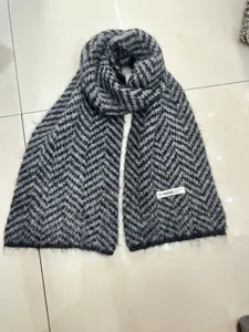 Morbida sciarpa in maglia con motivo chevron bianco e nero, accessorio invernale donna.