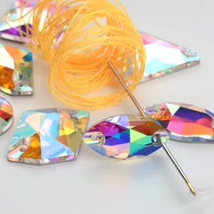 Close-up detail of AB electroplated shaped glass rhinestones with sewing needle and thread.