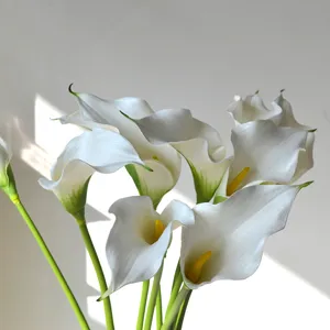Vue rapprochée détaillée d'une fleur de lys calla artificielle blanche avec tige verte.