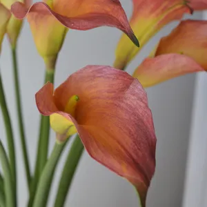 Gros plan de grande fleur de lys calla artificiel orange pour decoration interieure et mariage.