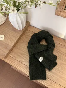Λεπτομέρεια πλεκτό κασκόλ από μείγμα μαλλιού σε σκούρο πράσινο, απαλή υφή και ζεστό.