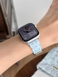 Cinturino per orologio in TPU blu trasparente con pois arancioni, primo piano al polso.
