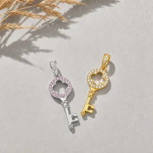 Detailed view of dual-tone key clover pendant with sparkling cubic zirconia stones.