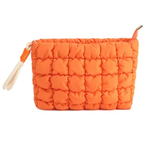 Oranje gewatteerde cosmetische etui detail, zachte puffer make-up tas met polsbandje.
