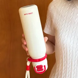 Detail view of portable kids thermos water bottle with red lid and hand strap, close up.