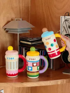 Detail shot of creative novelty baby bottle shaped ceramic mugs with colorful polka dots and handles.