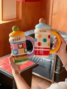 Detailed view of creative insulated cup with cute design, colorful heart pattern and handle.