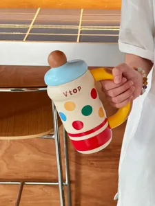 Detailed view of creative polka dot thermos water bottle with yellow handle and portable design.